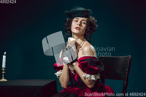 Image of Young woman as Anna Karenina on dark blue background. Retro style, comparison of eras concept.