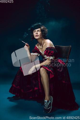 Image of Young woman as Anna Karenina on dark blue background. Retro style, comparison of eras concept.