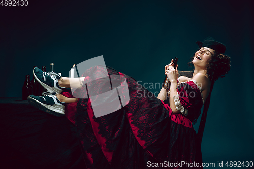 Image of Young woman as Anna Karenina on dark blue background. Retro style, comparison of eras concept.