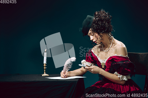 Image of Young woman as Anna Karenina on dark blue background. Retro style, comparison of eras concept.