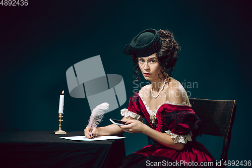 Image of Young woman as Anna Karenina on dark blue background. Retro style, comparison of eras concept.