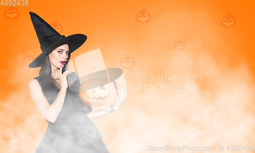 Image of Young woman a witch on scary background