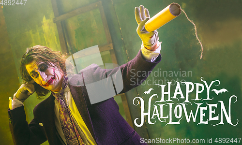 Image of Young man as a Joker on green background, halloween time, flyer with copyspace