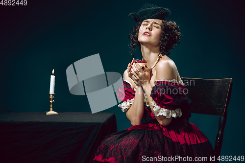 Image of Young woman as Anna Karenina on dark blue background. Retro style, comparison of eras concept.