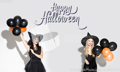 Image of Young attrective women in hat as a witch on scary background