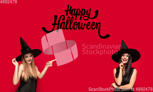 Image of Young attrective women in hat as a witch on scary background