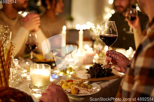 Image of friends drinking red wine at christmas party