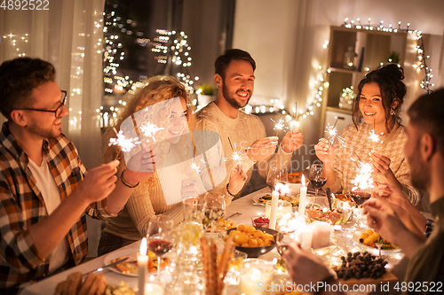 Image of happy friends having christmas dinner at home