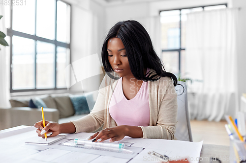 Image of female architect with house model and blueprint