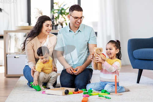 Image of happy family palying with wooden toys at home