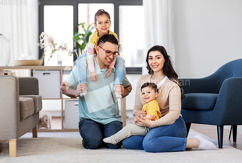 Image of portrait of happy family sitting on floor at home