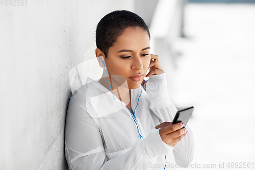 Image of african american woman with earphones and phone