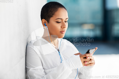 Image of african american woman with earphones and phone