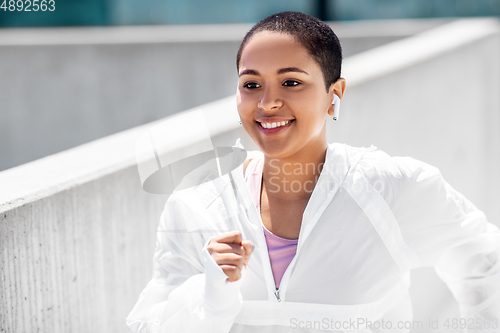 Image of african american woman running upstairs outdoors