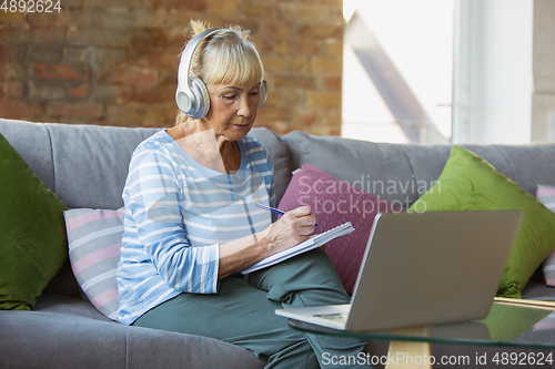 Image of Senior woman studying at home, getting online courses