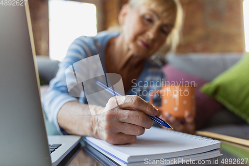 Image of Senior woman studying at home, getting online courses