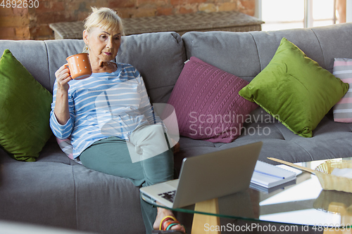 Image of Senior woman studying at home, getting online courses