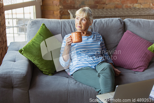 Image of Senior woman studying at home, getting online courses