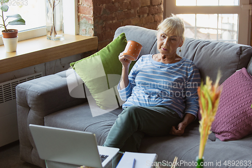 Image of Senior woman studying at home, getting online courses