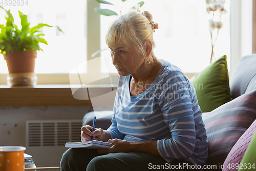 Image of Senior woman studying at home, getting online courses