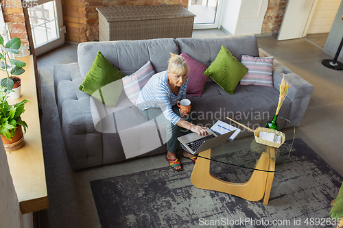 Image of Senior woman studying at home, getting online courses