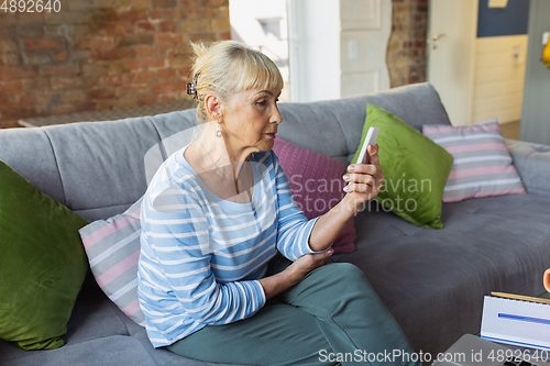 Image of Senior woman studying at home, getting online courses