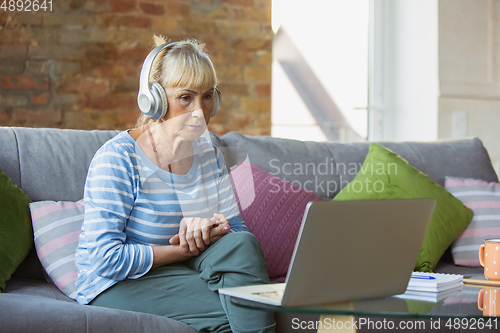 Image of Senior woman studying at home, getting online courses