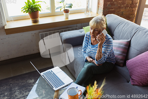 Image of Senior woman studying at home, getting online courses