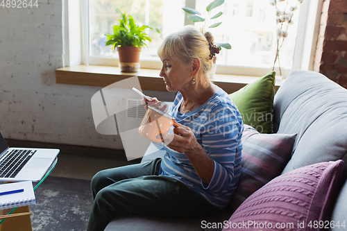 Image of Senior woman studying at home, getting online courses