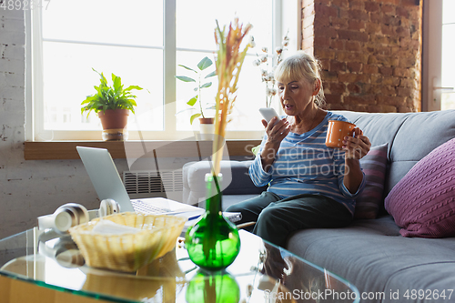 Image of Senior woman studying at home, getting online courses