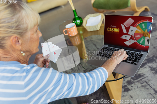 Image of Senior woman studying at home, getting online courses