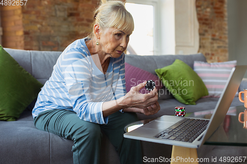 Image of Senior woman studying at home, getting online courses