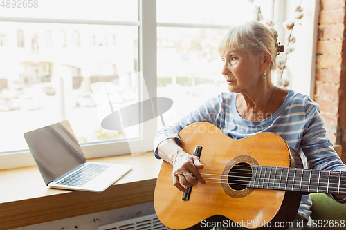 Image of Senior woman studying at home, getting online courses