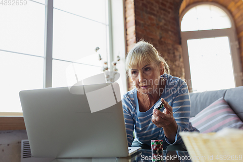 Image of Senior woman studying at home, getting online courses