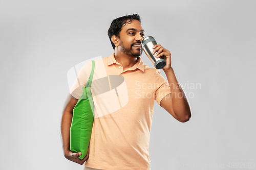 Image of man with food in bag and tumbler or thermo cup