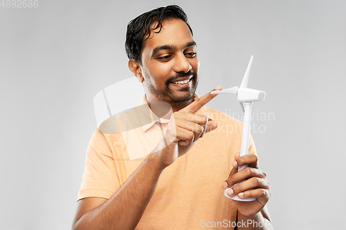 Image of smiling young man with toy wind turbine