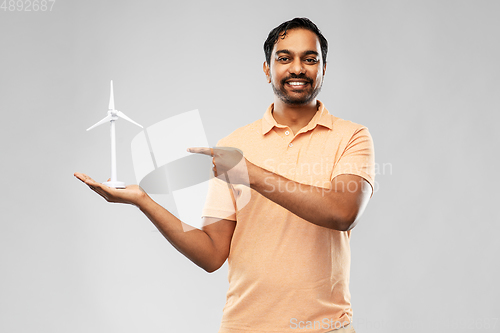 Image of smiling young man with toy wind turbine