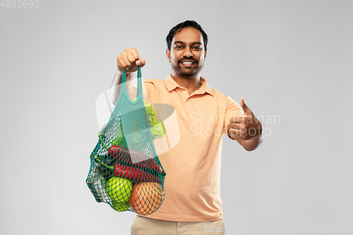 Image of happy indian man with food in reusable net tote