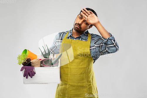 Image of tired gardener or farmer with box of garden tools