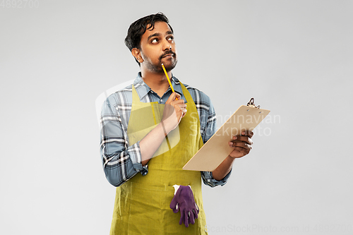 Image of indian gardener or farmer with clipboard thinking