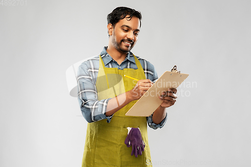 Image of happy indian gardener or farmer with clipboard