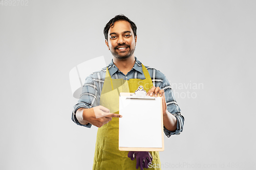 Image of happy indian gardener or farmer showing clipboard