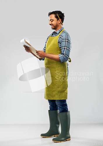 Image of happy indian gardener or farmer with clipboard