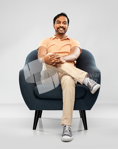 Image of happy smiling young indian man sitting in chair