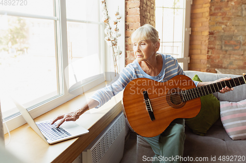 Image of Senior woman studying at home, getting online courses