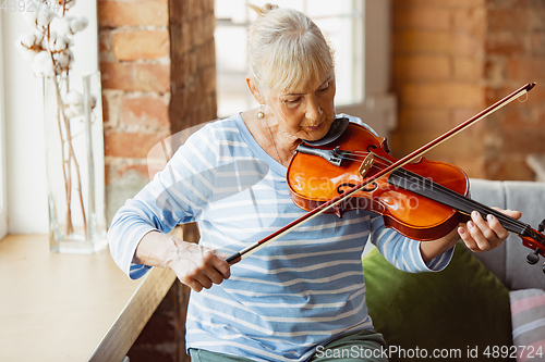 Image of Senior woman studying at home, getting online courses