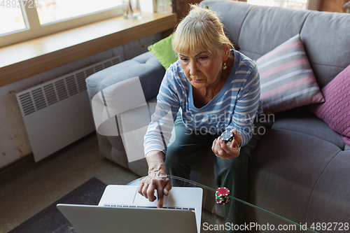 Image of Senior woman studying at home, getting online courses