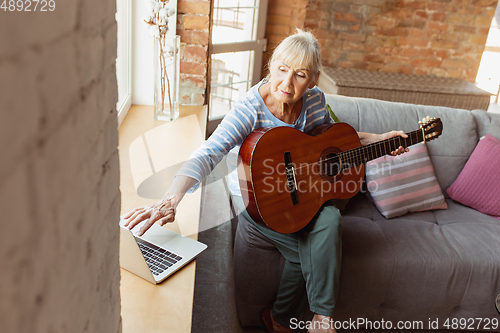 Image of Senior woman studying at home, getting online courses