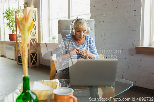 Image of Senior woman studying at home, getting online courses