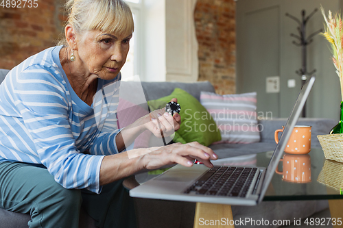 Image of Senior woman studying at home, getting online courses